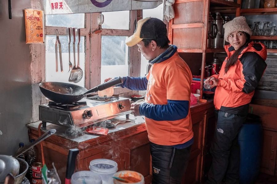 Local staff cooking in rustic teahouse kitchen with gas stoves